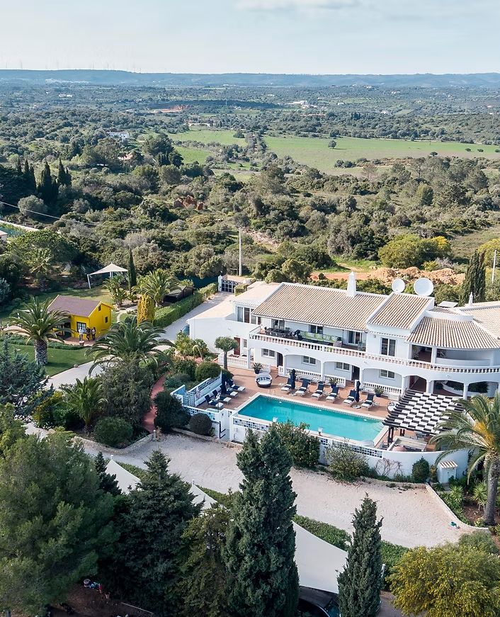 Aerial view of Casa Monte Cristo and its pool among green hills