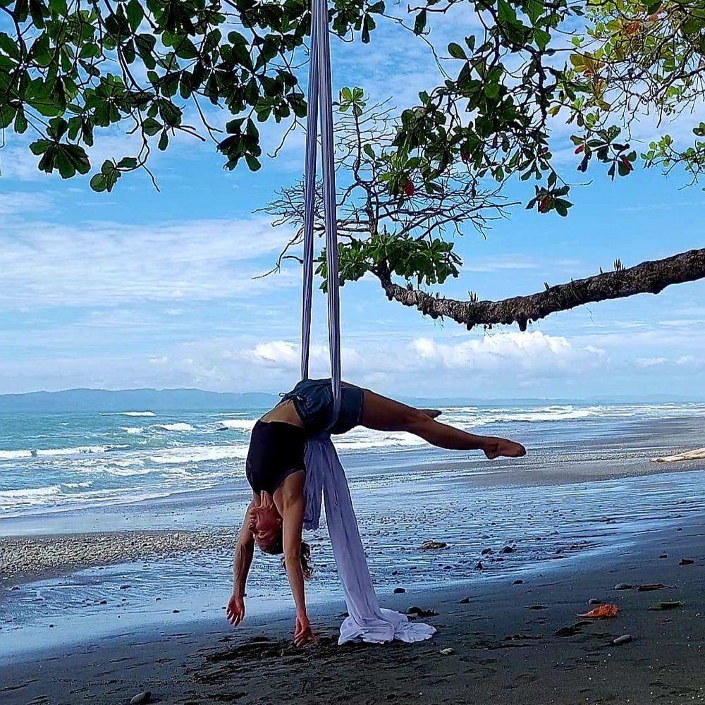 Julia Torggler inverted on silks on a beach