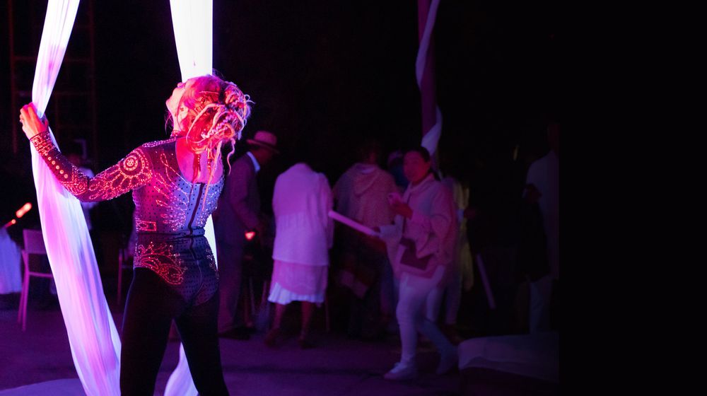 Aerialist performing on silks at a night show