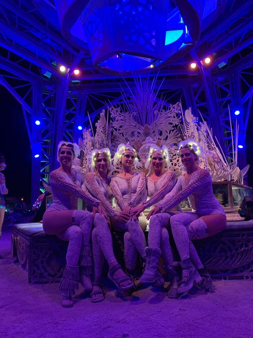 Performers on stage under purple lights
