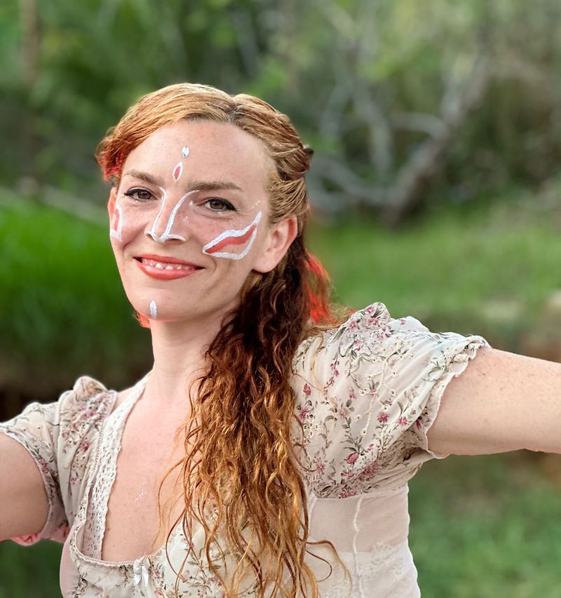 Performer with white face paint in the garden