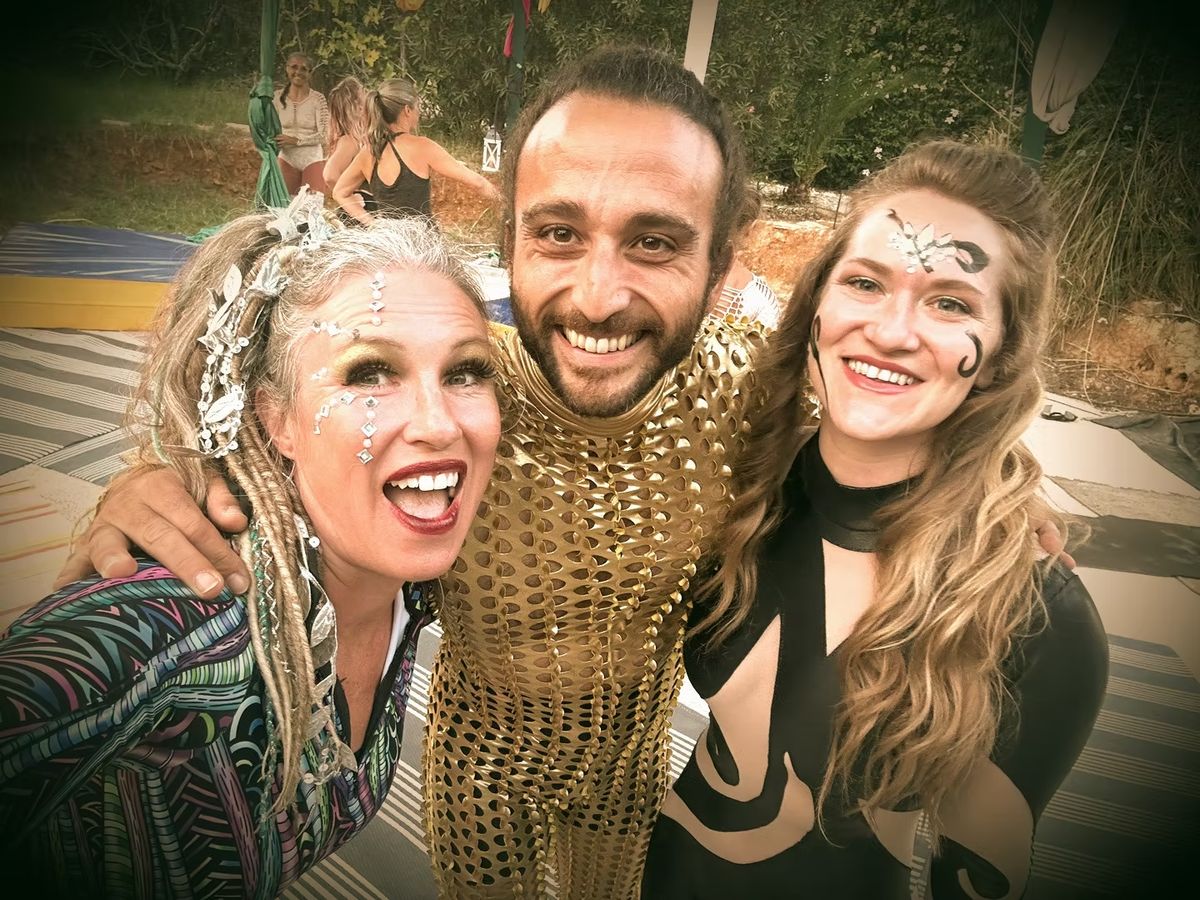 Three friends in sparkling costumes and face jewels