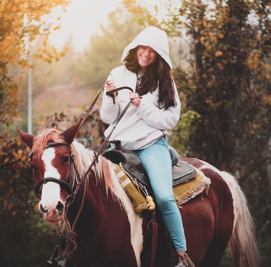 Smiling woman on horseback in the countryside