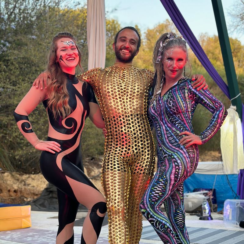 Three performers in sparkling costumes