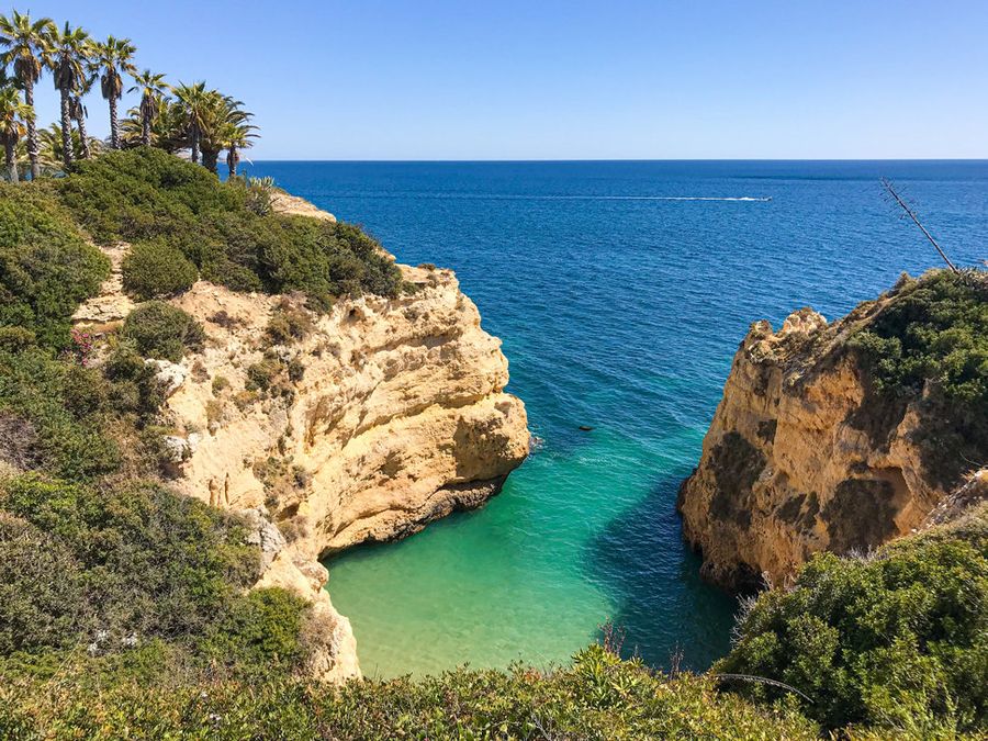Turquoise cove below golden cliffs