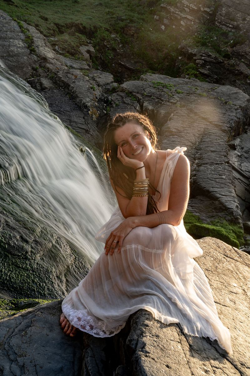 Chloe smiling beside a waterfall